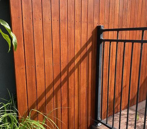 Picture of a timber boundary fence intersecting with a pool fence